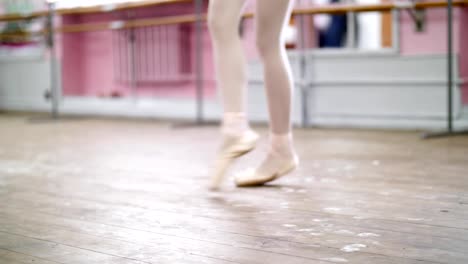 close-up,-in-ballet-class,-on-an-old-wooden-floor,-ballerina-performs-glissade-en-tournant,-She-moving-through-the-ballet-class-elegantly