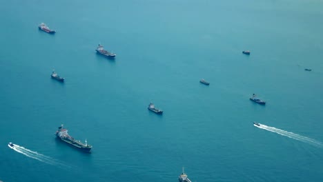 Travel-video-View-from-the-airplane-window-through-the-wings-and-engine-Flying-through-the-ocean-and-the-cargo-ship-is-sailing-in-the-sea-near-the-shipping-port-in-transportation-or-travel-concept.