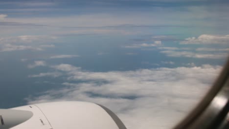 Motor-de-avión-en-vuelo-vista-a-través-de-una-ventana-de-avión-viendo-nubes-para-viajar-alrededor-del-mundo