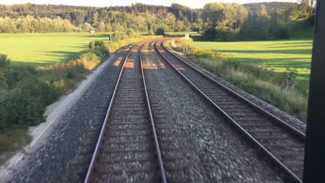 Filmen-aus-der-Heckscheibe-des-Fahrens-Zug-durch-schöne-Landschaft-im-Sommer