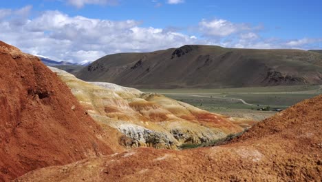 Rot-und-orange-Hügel-vor-der-Kulisse-der-Berge