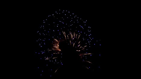 Fireworks-on-a-dark-night-sky.-Stunning-beautiful-lights-in-the-center-are-crowded,-long-threads-of-sparks-diverge-from-both-sides,-blue-lights-are-scattered-all-over-the-sky