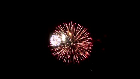 Hellen-Feuerwerk-auf-der-Ferieninsel.-In-der-Nacht-Himmel-einen-hellen-Feuerball-crimson-glänzt.-Eine-interessante-Kugel-befindet-sich-im-Zentrum-von-Feuerwerkskörpern,-um-kleine-Kugeln-in-verschiedenen-Farben