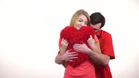 Couple-holds-red-heart-shaped-pillow-love-symbol-4K