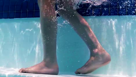 Junge-zu-Fuß-unter-Wasser-auf-Schritte-im-Schwimmbad