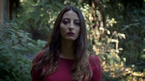 Serious-sexy-young-woman-walking-in-the-park-staring-at-camera