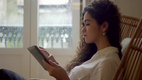 Chica-atractiva-con-el-pelo-rizado-con-tablet-pc-en-el-hogar