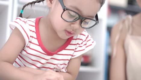 Una-niña-sentada-y-leyendo-con-su-madre.