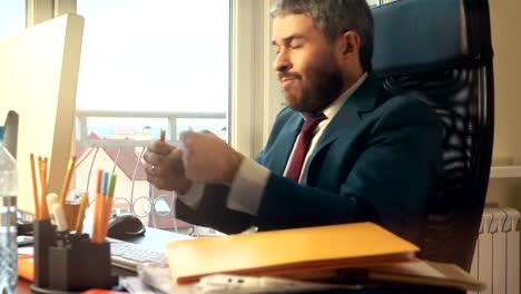 Young-bearded-businessman-getting-angry-and-breaking-the-pencil-after-receiving-an-email.-FullHD-video