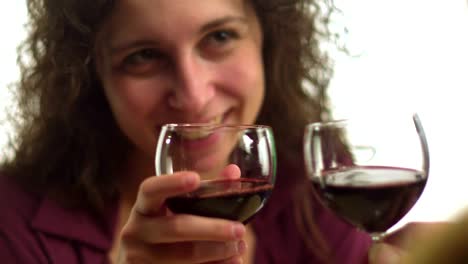 Woman-and-man-drink-wine-together-after-toasting-glasses