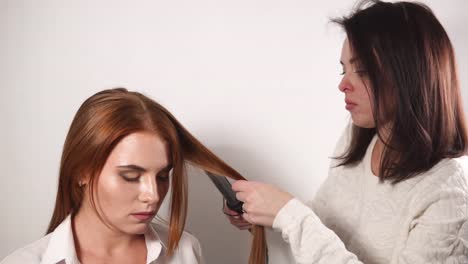 Estilista-es-rizar-modelos-de-cabello-en-la-tenaza-y-esperando