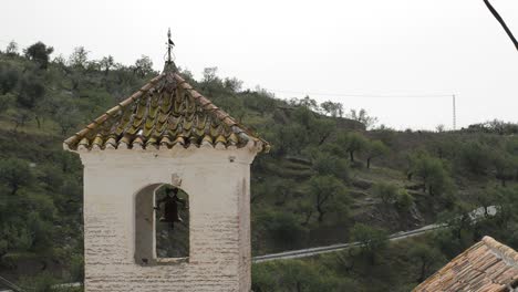 Antique-bell-tower-in-a-church-built-on-an-Arab-minaret-in-Daimalos,-Spain