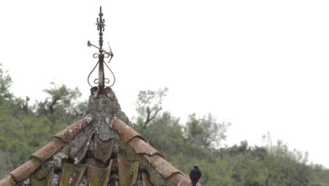 Alten-Wetterfahne-in-Form-eines-Kreuzes-auf-einem-alten-Glockenturm-einer-kleinen-Kirche