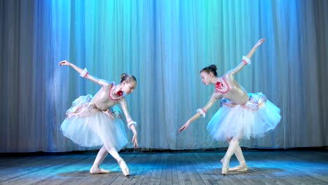 Ballett-Probe-auf-der-Bühne-des-alten-Theatersaal.-Junge-TänzerInnen-in-eleganten-Kleidern-und-Spitzenschuhe,-Tanz,-elegant-bestimmte-Ballett-Bewegungen,-Pass,-landschaftliche-Bogen