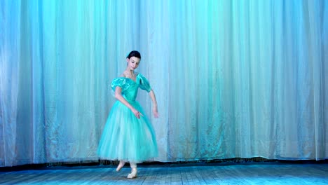 ballet-rehearsal,-on-the-stage-of-the-old-theater-hall.-Young-ballerina-in-blue-ballet-dress-and-pointe-shoes,-dances-elegantly-certain-ballet-motion,-arabesque
