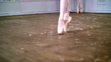 close-up,-in-ballet-class,-on-an-old-wooden-floor,-ballerina-performs-glissade-en-tournant,-She-moving-through-the-ballet-class-elegantly