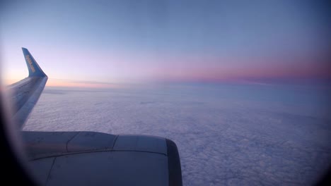 Nubes-púrpura-vistas-a-través-de-la-ventana-del-avión-a-reacción-en-la-puesta-de-sol.-HD-vídeo-alta-definición