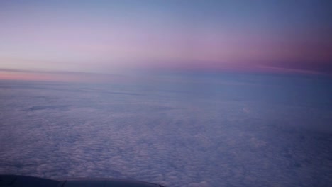 Nubes-púrpura-vistas-a-través-de-la-ventana-del-avión-a-reacción-en-la-puesta-de-sol.-HD-vídeo-alta-definición