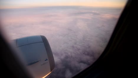 Nubes-púrpura-vistas-a-través-de-la-ventana-del-avión-a-reacción-en-la-puesta-de-sol.-HD-vídeo-alta-definición