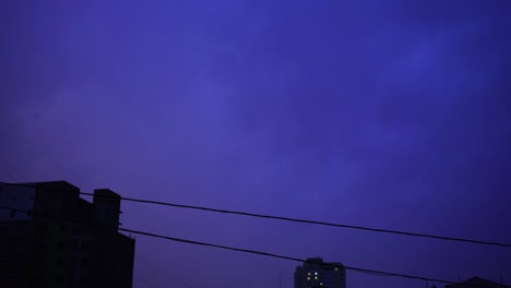 Relámpago-en-el-cielo-nocturno-de-la-ciudad,-un-brillante-destello-de-luz-en-las-nubes-en-la-lluvia,-una-tormenta-eléctrica