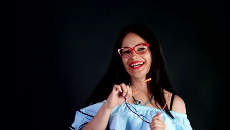 portrait-of-a-sexy-brunette-woman-with-red-lips-who-eroticly-and-playfully-tries-on-different-pairs-of-stylish-eyeglasses,-spectacles-and-looking-sexually-at-camera-in-studio