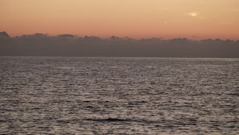 Red-orange-sky-after-sunset-over-sea-surface