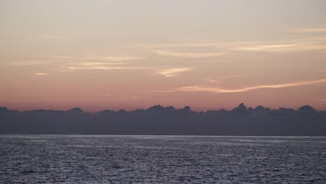 Rot-orange-Himmel-nach-Sonnenuntergang-über-der-Meeresoberfläche