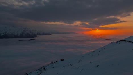 Timelapse-de-la-puesta-de-sol-sobre-las-montañas-cubiertas-de-nieve-y-nieblas