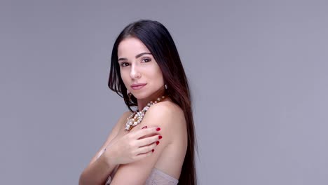 Beautiful-woman-posing-in-studio.-She-shows-women's-jewelry