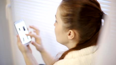 compras-en-línea,-una-mujer-joven,-viendo-los-productos-en-la-tienda-online-en-la-pantalla-del-smartphone