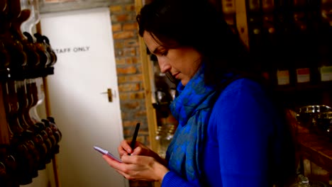 Side-view-of-woman-writing-on-notepad-in-supermarket-4k