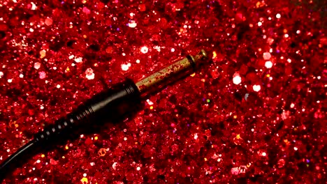 Black-cable-on-the-background-of-red-glitter