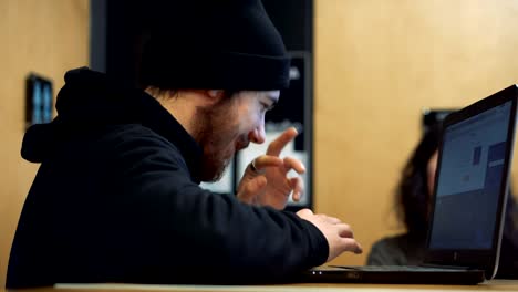 Young-man-working-with-laptop-in-a-cafe