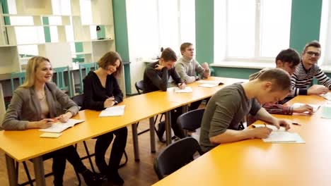 Woman-teacher-standing-in-front-of-students-during-a-lesson-in-classroom