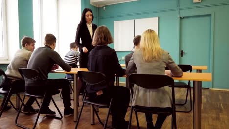 Maestro-anda-pasado-de-escritorio-y-verificación-de-progreso-de-los-estudiantes-durante-una-clase