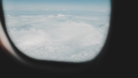 Clouds-seen-through-the-window-of-jet-airplane.-Airplane-flies-above-the-weather