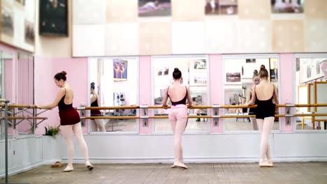 en-baile-de-salón,-jóvenes-bailarinas-en-negro-leotards-realizan-grand-battement-a-barre,-elegantemente,-de-pie-junto-a-la-barra-en-espejo-en-clase-de-ballet