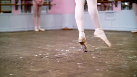 in-dancing-hall,-Young-ballerina-in-black-leotard-performs-glissade-en-tournant,-She-moving-through-the-ballet-class-elegantly