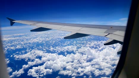 Travel-video-View-from-the-airplane-window-through-the-wings-and-engine-While-flying-through-the-cloud-and-bluesky-in-transportation-or-travel-concept.