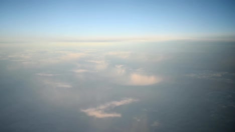 Nubes-azules-y-whithe-vistas-a-través-de-la-ventana-del-avión-a-reacción-en-día-soleado.-HD-vídeo-alta-definición