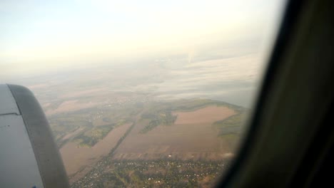 Paisaje-visto-a-través-de-la-ventana-del-avión-a-reacción-en-día-soleado.-Ver-en-movimiento.-HD-vídeo-alta-definición