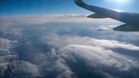 Beautiful-view-through-airplane-window,-airplane-flying-above-city-in-mountains