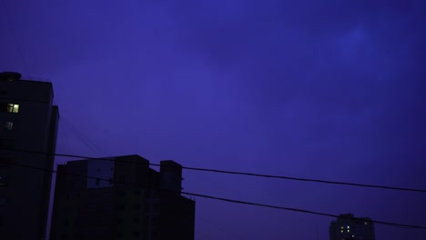 Relámpago-en-el-cielo-nocturno-de-la-ciudad,-un-brillante-destello-de-luz-en-las-nubes-en-la-lluvia,-una-tormenta-eléctrica