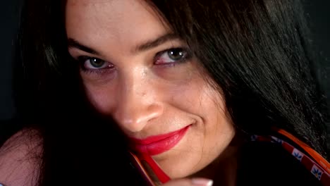 portrait-of-a-sexy-brunette-woman-with-red-lips-who-eroticly-and-playfully-tries-on-different-pairs-of-stylish-eyeglasses,-spectacles-and-looking-sexually-at-camera-in-studio