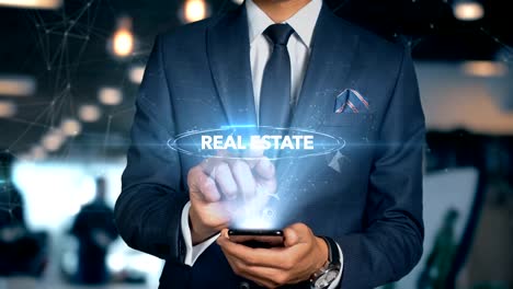 Businessman-With-Mobile-Phone-Opens-Hologram-HUD-Interface-and-Touches-Word---REAL-ESTATE