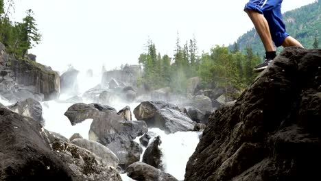 The-traveler-scrambles-along-the-cascading-waterfall.