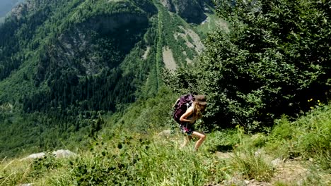 Woman-climber-hiker-tourist-rises-uphill-in-the-background-of-beautiful-scenery