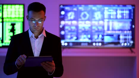 The-businessman-with-a-tablet-standing-on-the-displays-background