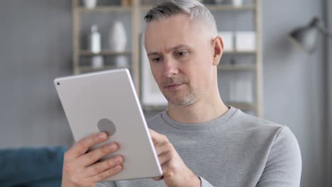 Hombre-de-pelo-gris-con-tableta-en-el-lugar-de-trabajo