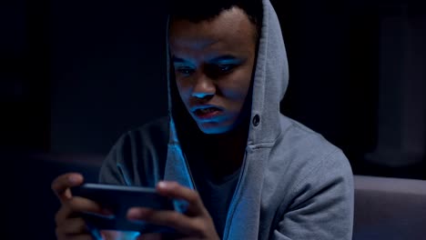 Extremely-emotional-black-guy-winning-video-game-on-smartphone,-overreacting